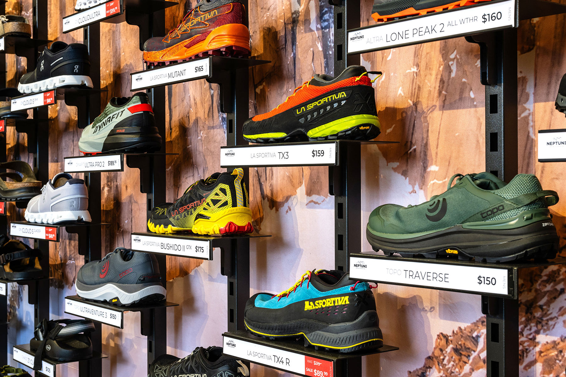 Outdoor shoes on display on wall racks.